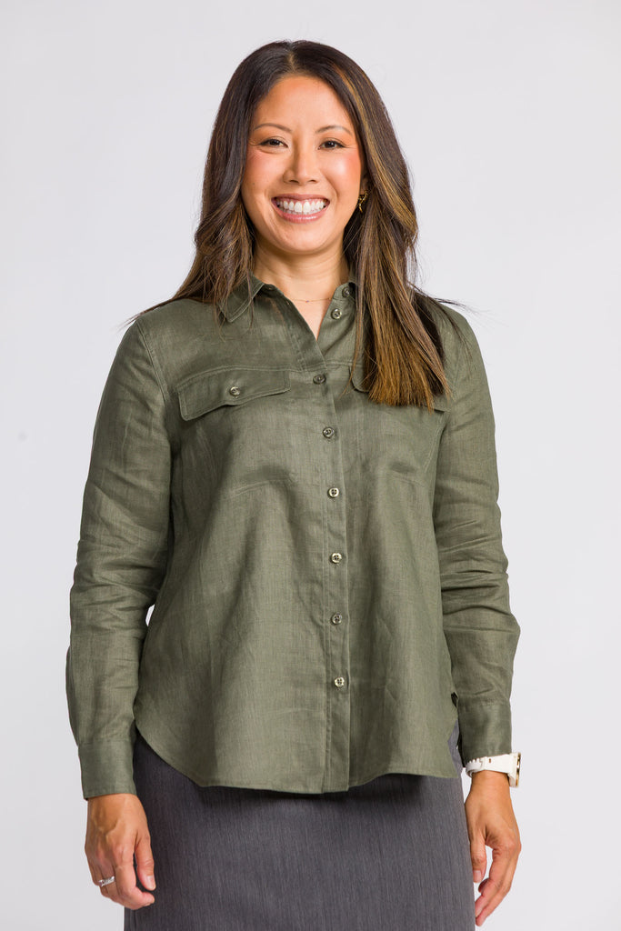 Woman wearing a green button-up shirt against a white background