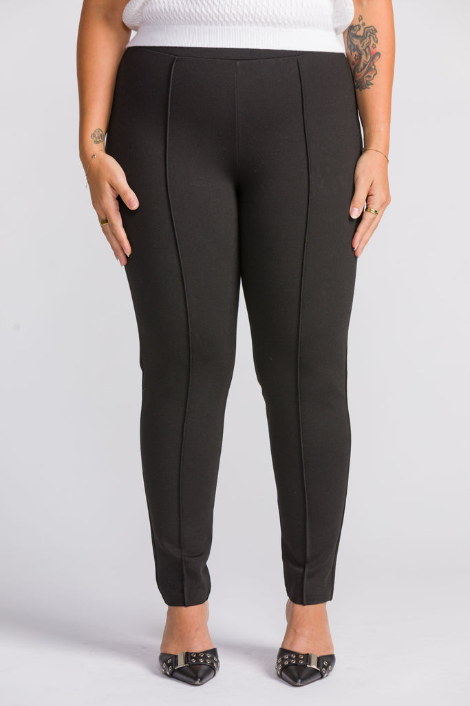 Woman wearing black Ponte leggings on a white background