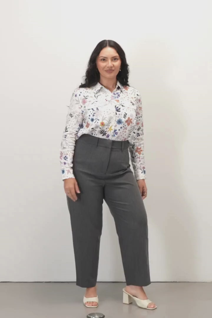 Tilly Tailored Pants - Charcoal - Woman wearing a floral blouse and gray pants on a white background