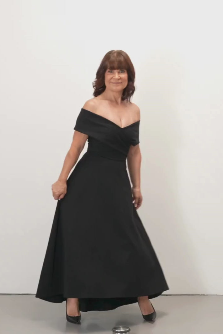 Jenny Evening Dress - Woman wearing a black off-shoulder dress on a white background