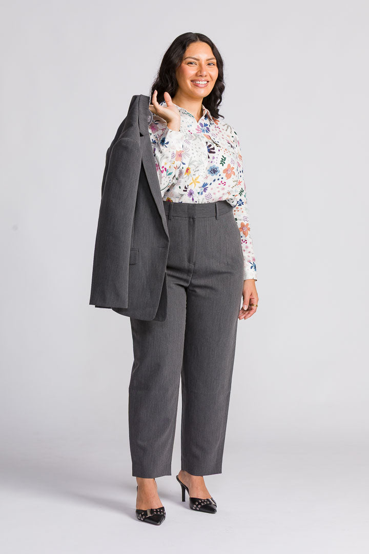 Petite model wearing a floral blouse with grey tailored pants and blazer, designed for women 158cm and under, showcasing a polished petite workwear outfit.